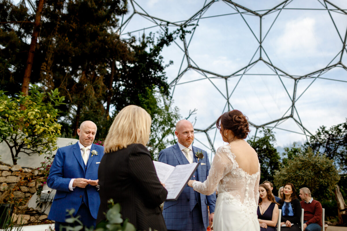 bride and groom exchanging vows beneath the Mediterranean Biome roof