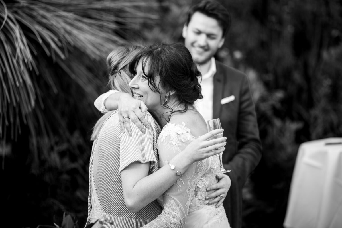 Black and white photograph of the bride hugging her friend